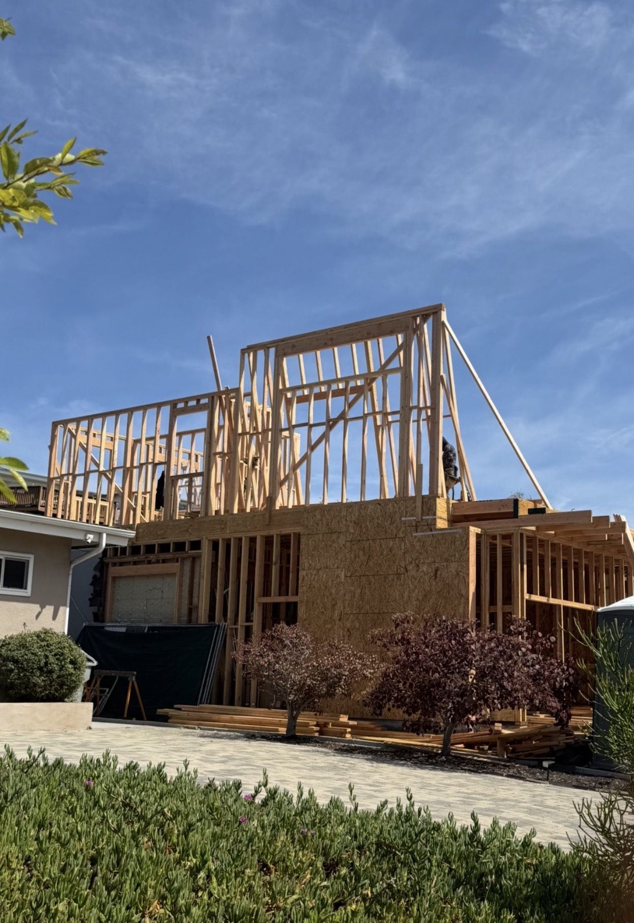 Three-story residential addition framed against a blue sky