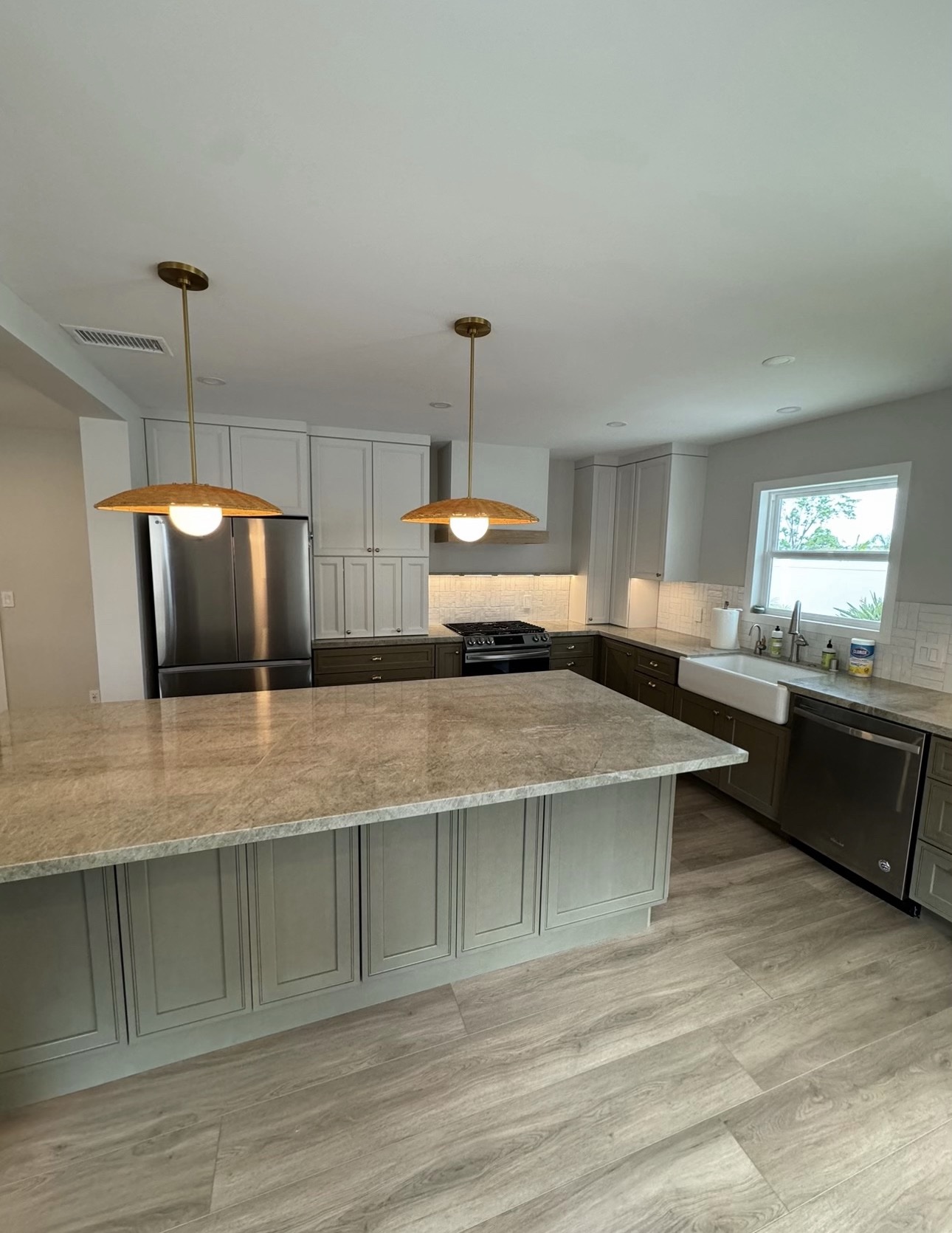 Finished expanded kitchen with a sage-green island and marble top