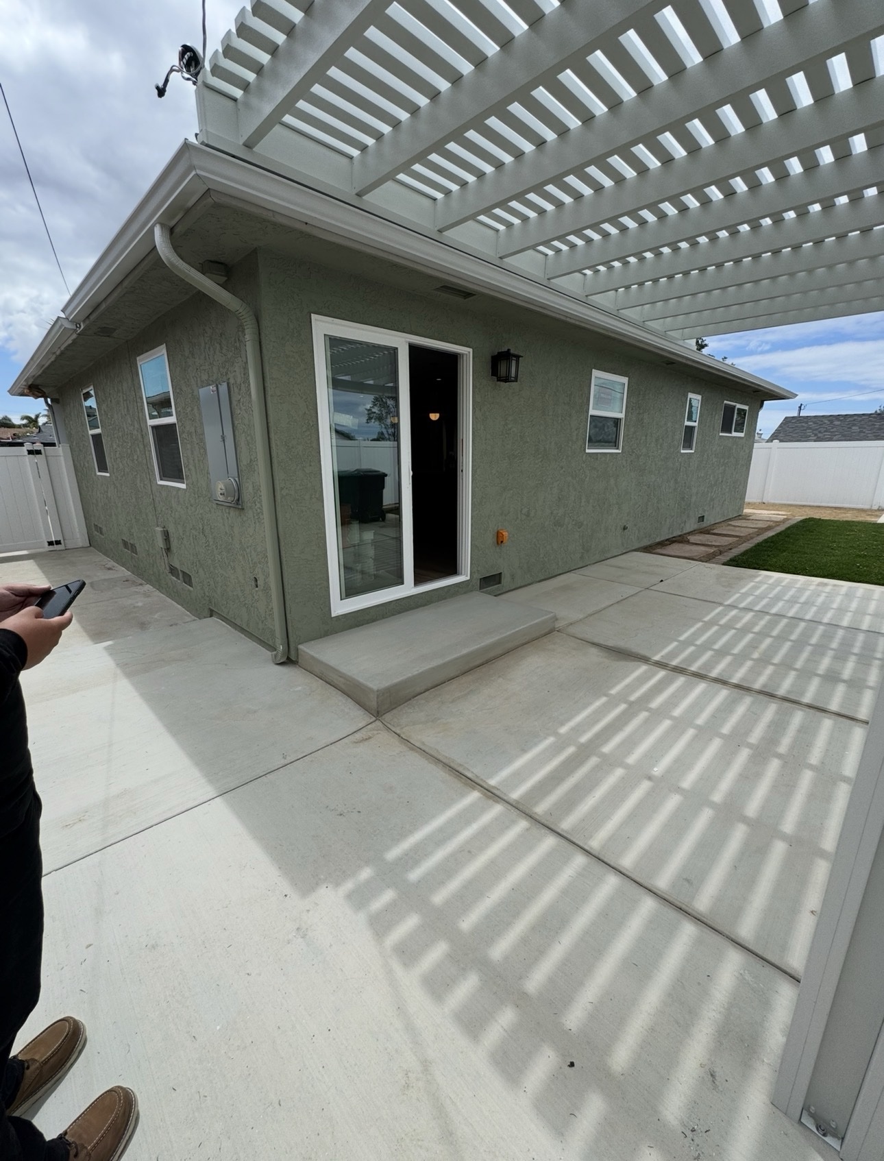 Completed home addition with green stucco finish and new patio doors