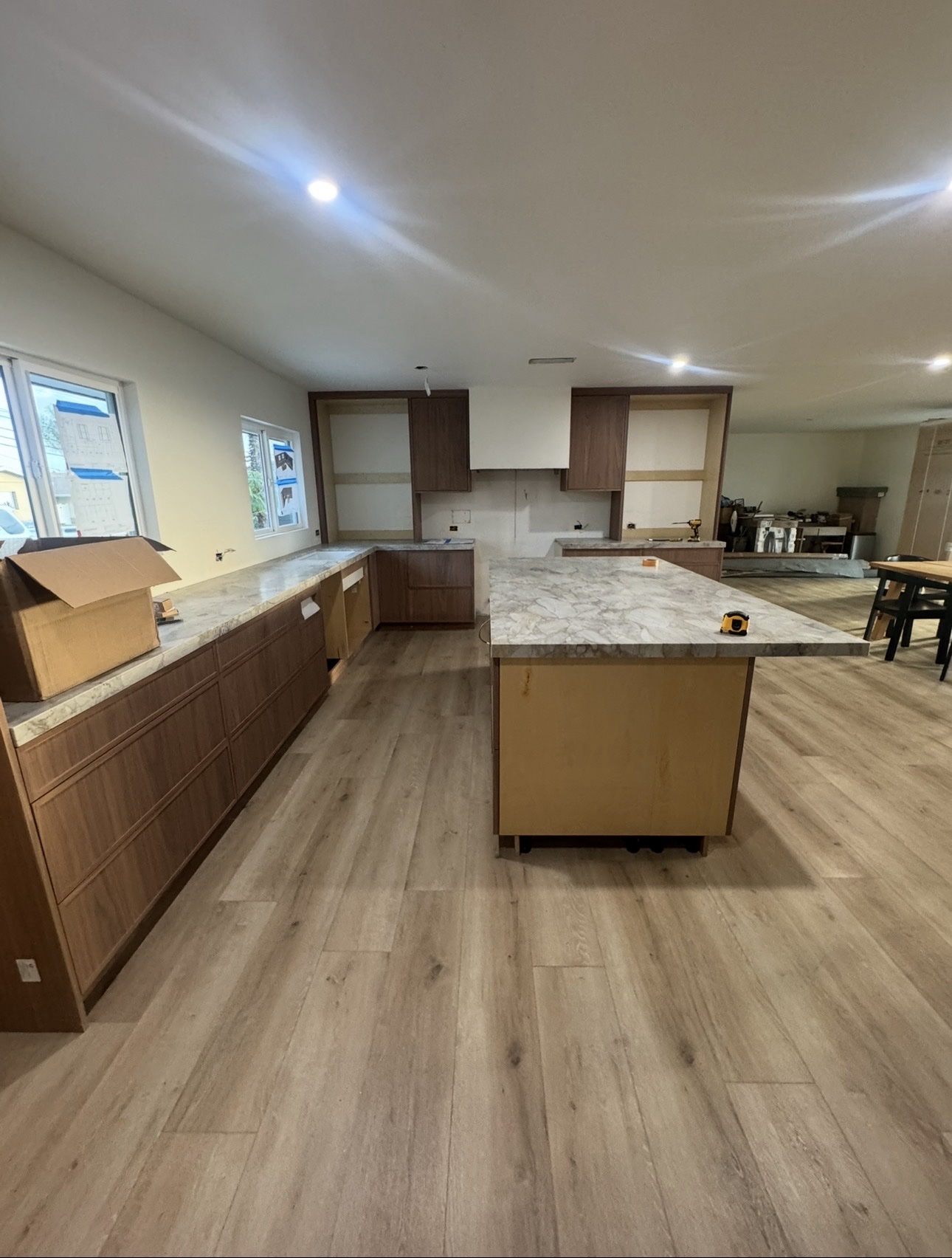 Walnut cabinetry and marble island being installed in a kitchen