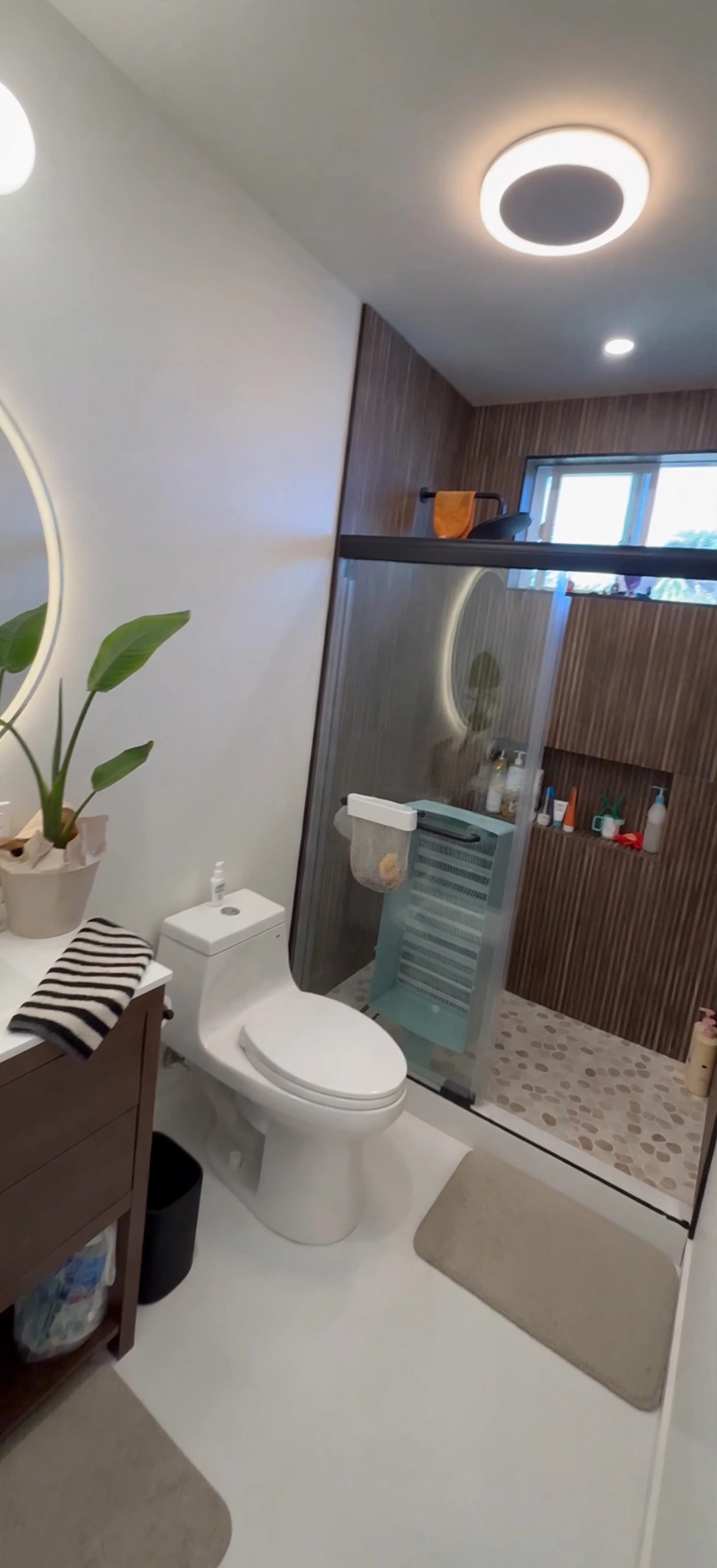 Finished Galveston ADU bathroom with a glass walk-in shower, pebble floor and wood-look tile